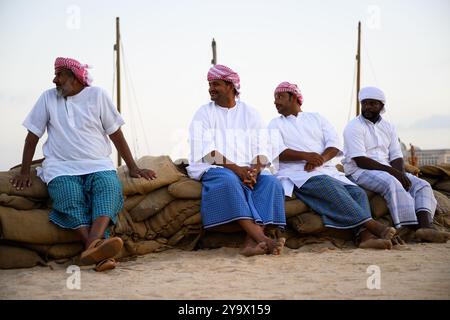 Doha, Qatar - 29 novembre 2023 : un homme arabe répare un filet de pêche pendant le festival des roulements à voile dans le village de Katara. Banque D'Images