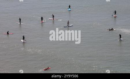 Arrière-plan de la nature. Seascape avec silhouette de groupe de personnes dans la mer de distance avec sur les planches de surf faisant standup paddle Banque D'Images