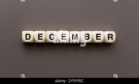 Symbole de décembre. Mot conceptuel décembre sur des blocs de bois sur beau fond brun, pose plate, espace de copie. Banque D'Images