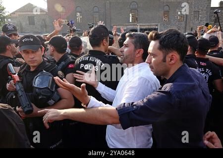 Mehmet Sirin Gurbuz (en chemise blanche), coprésident provincial du Parti des régions démocratiques (DBP) de Diyarbakir, se disputant avec des policiers bloquant les manifestants pendant le rassemblement. Les partis et organisations politiques kurdes ont organisé diverses manifestations à l'occasion de l'anniversaire de la capture d'Abdullah Ocalan, chef de l'organisation kurde armée Parti des travailleurs du Kurdistan (PKK), au Kenya en 1999. La marche et la manifestation à Diyarbakir ont appelé à une solution démocratique au problème kurde en Turquie. Il a été annoncé que le rassemblement de la « Grande Marche pour la liberté » devait se tenir à Diyarbakir le 13 Octo Banque D'Images