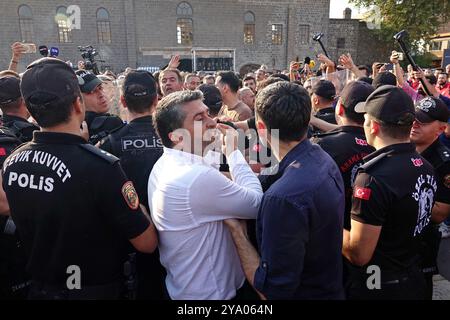 Mehmet Sirin Gurbuz (en chemise blanche), coprésident provincial du Parti des régions démocratiques (DBP) de Diyarbakir, se disputant avec des policiers bloquant les manifestants pendant le rassemblement. Les partis et organisations politiques kurdes ont organisé diverses manifestations à l'occasion de l'anniversaire de la capture d'Abdullah Ocalan, chef de l'organisation kurde armée Parti des travailleurs du Kurdistan (PKK), au Kenya en 1999. La marche et la manifestation à Diyarbakir ont appelé à une solution démocratique au problème kurde en Turquie. Il a été annoncé que le rassemblement de la « Grande Marche pour la liberté » devait se tenir à Diyarbakir le 13 Octo Banque D'Images