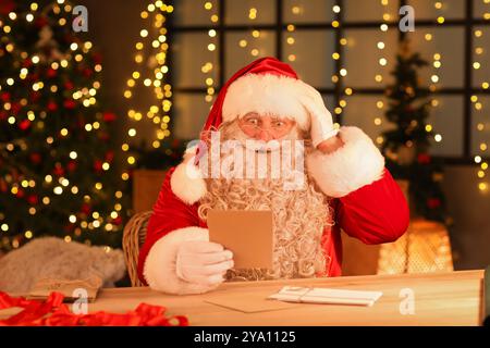 Le Père Noël choqué avec des lettres à la maison la veille de Noël Banque D'Images
