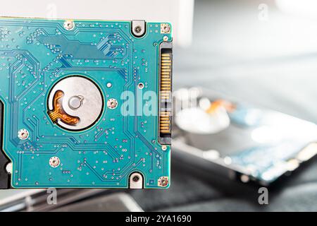 Gros plan d'un disque dur (HDD) présentant la carte de circuit imprimé interne et ses composants. L'image met en évidence les détails complexes de l'électronique Banque D'Images