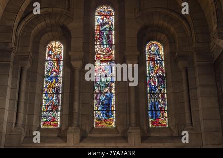 Trois vitraux dans une église, illuminés de différentes scènes religieuses, Paris Banque D'Images