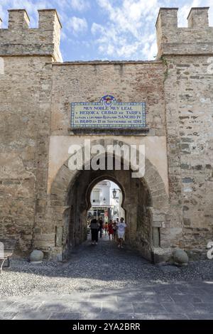 Vieille porte de la ville avec des murs de pierre et un passage à travers lequel les gens marchent, Tarifa Banque D'Images