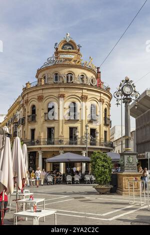 Un bâtiment historique avec une tour et une horloge, entouré de gens et de cafés de rue, Jerez Banque D'Images