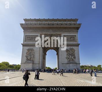 Vue de face de l'Arc de Triomphe, les gens marchant sous le ciel ensoleillé, Paris Banque D'Images