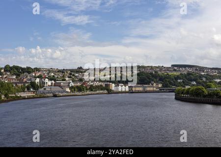 Vue sur la rivière à la ville avec des maisons et le ciel bleu, Londonderry Banque D'Images