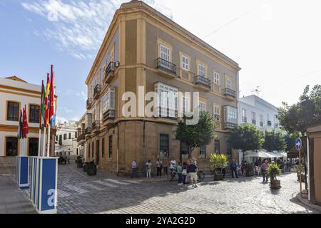 Bâtiment d'angle dans un style architectural traditionnel dans une rue animée avec des gens, Tarifa Banque D'Images