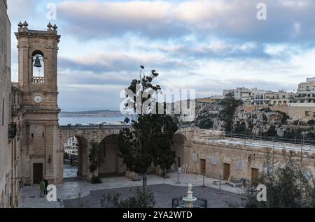 Mellieha, Malte, 01 07 2022 : vue sur la cathédrale, les montagnes et le village pendant le coucher du soleil, Europe Banque D'Images