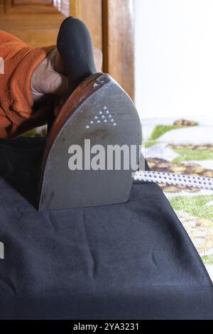 Gros plan des mains d'une femme repassant. Mains d'une femme âgée repassant une serviette Banque D'Images