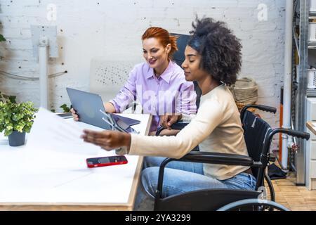 Diverses collègues féminines travaillant ensemble dans une salle de réunion dans un coworking Banque D'Images