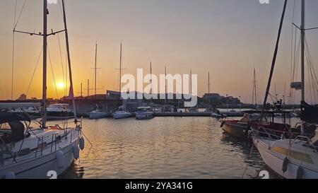 Coucher de soleil serein dans un port avec des bateaux amarrés dans des eaux calmes, dans la vieille ville de Nessebar, Bulgarie, Europe Banque D'Images