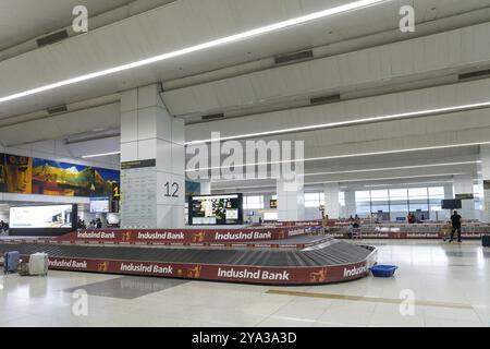 Delhi, Inde, le 30 mars 2023 : des personnes attendent aux tapis transporteurs de récupération des bagages dans la zone d'arrivée de l'aéroport international Indira Gandhi, en Asie Banque D'Images