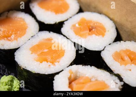 Gros plan de sushi maki frais avec du saumon dans une boîte à emporter Banque D'Images