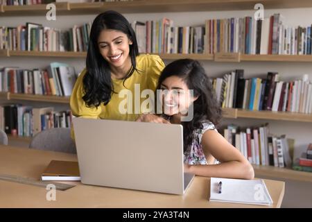 Joyeuse jeune adulte étudiante indienne aidant un ami de collège Banque D'Images