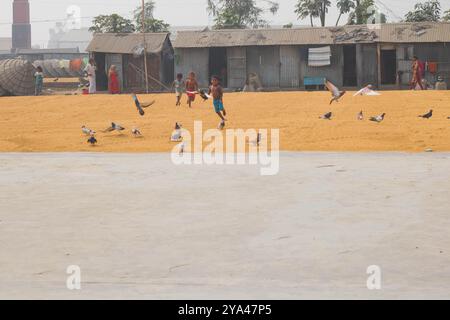 Ashuganj, Brahmanbaria, 26 janvier 2023, les travailleurs travaillant dans un petit moulin à riz, le riz traditionnel traite le séchage des grains de paddy au soleil du Bangladesh. Banque D'Images