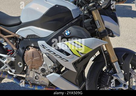Gros plan d'une moto bmw s 1000 rr blanche et noire aux accents jaunes garée sur une route asphaltée Banque D'Images