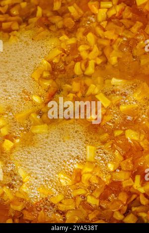 pommes jaunes tranchées bouillant dans du sirop pendant la cuisson des confitures Banque D'Images