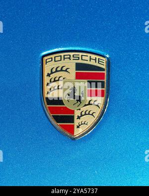Londres, Royaume-Uni, 18 septembre 2024 ; logo de la voiture Porsche sur fond bleu vue de dessus. Porsche est un constructeur automobile allemand. Banque D'Images