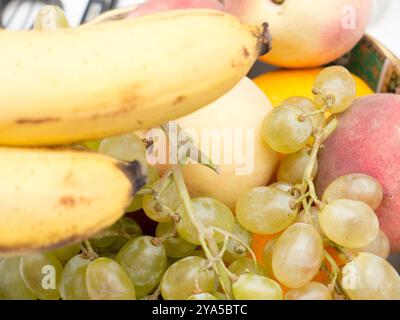 Nature morte de raisins, pêches et bananes dans une assiette. Banque D'Images