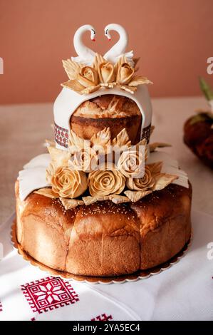 Gâteau de mariage exquis orné d'élégants cygnes et roses de sucre. Banque D'Images