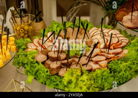 Plateau de charcuterie gastronomique exquis avec légumes verts frais et viandes assorties. Banque D'Images