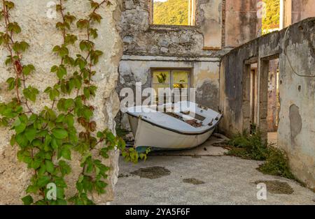 Un vieux bateau de pêche qui fuyait a débarqué dans le port de Trpanj Banque D'Images