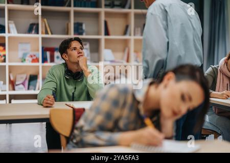 Les étudiants écoutent attentivement le professeur âgé en classe Banque D'Images