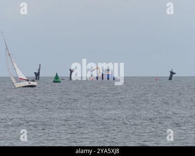 Sheerness, Kent, Royaume-Uni. 12 octobre 2024. Les travaux visant à rétablir un anneau de bouées de « danger » autour de l'épave du SS Richard Montgomery ont été entrepris dans la Tamise aujourd'hui par le navire ShakeDog. Les bouées distinctives rouge vif avec le mot « danger » écrit dessus avertissent les marins de ne pas entrer dans une zone d'exclusion en forme de losange de 250 m autour de l'épave, qui est surveillée 24/7 par les autorités en raison du naufrage du navire avec 1400 tonnes d'explosifs en 1944. Les 12 bouées rouges ont été retirées temporairement en novembre dernier pour aider à des travaux spéciaux d'arpentage. Crédit : James Bell/Alamy Live News Banque D'Images