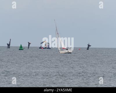 Sheerness, Kent, Royaume-Uni. 12 octobre 2024. Les travaux visant à rétablir un anneau de bouées de « danger » autour de l'épave du SS Richard Montgomery ont été entrepris dans la Tamise aujourd'hui par le navire ShakeDog. Les bouées distinctives rouge vif avec le mot « danger » écrit dessus avertissent les marins de ne pas entrer dans une zone d'exclusion en forme de losange de 250 m autour de l'épave, qui est surveillée 24/7 par les autorités en raison du naufrage du navire avec 1400 tonnes d'explosifs en 1944. Les 12 bouées rouges ont été retirées temporairement en novembre dernier pour aider à des travaux spéciaux d'arpentage. Crédit : James Bell/Alamy Live News Banque D'Images