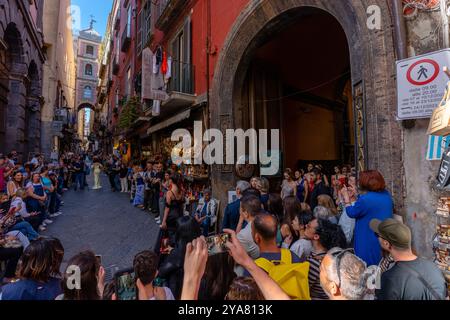 Naples, Italie - 23 mai 2024 : la foule se rassemble pour un défilé de mode à Naples : téléphones et appareils photo prêts. Banque D'Images