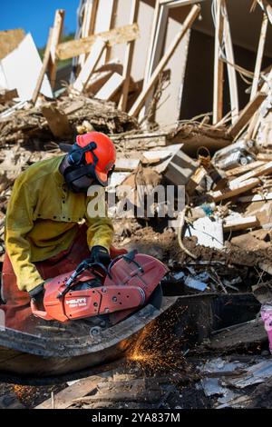 Comté de Washington, États-Unis. 11 octobre 2024. L'aviateur principal de la Garde nationale de l'air des États-Unis, Dylan Potts, avec le 134e civil Engineer Squadron, utilise un outil de coupe pour enlever les débris métalliques à la suite des inondations causées par l'ouragan Helene, le 11 octobre 2024 dans le comté de Washington, Tennessee. Crédit : Sgt. Everett Babbitt/US Air Force/Alamy Live News Banque D'Images