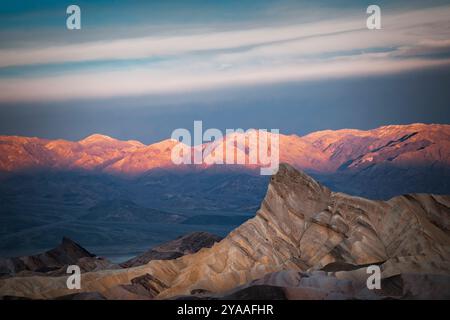 Le soleil se lève au-dessus de Manly Beacon dans le parc national de la Vallée de la mort, en Californie, attrapant les sommets de la chaîne Panamint depuis Zabriskie point. Banque D'Images