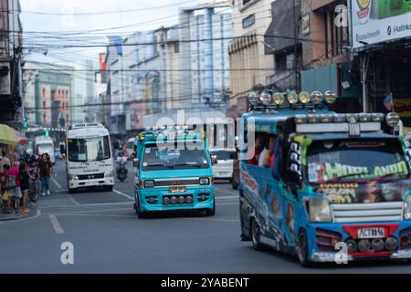 La circulation circule régulièrement le long de Colon Street à Cebu City, aux Philippines, la plus ancienne rue du pays. Jeepneys, voitures et motos naviguent dans la bustline Banque D'Images