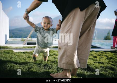 Un tout-petit joyeux s'engageant dans le jeu en plein air avec un parent dans un paysage pittoresque Banque D'Images