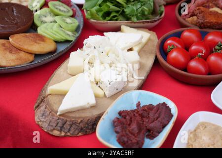 Une planche à fromage rustique avec un assortiment de fromages exposés sur un plateau en bois Banque D'Images