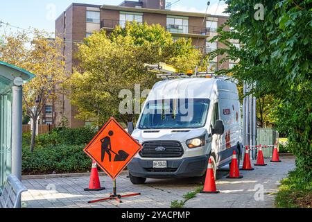 Une fourgonnette portant le logo Aecon est garée à côté d'un panneau indiquant des travaux de construction sur le trottoir. Banque D'Images