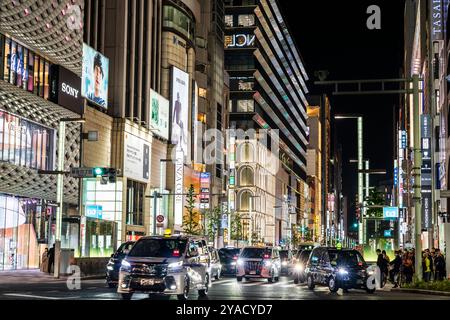 Trafic traversant le célèbre carrefour de Ginza 4 la nuit avec arrière-plan des bâtiments Ginza Core et Ginza six. Entrées de la station de métro. Nuit. Banque D'Images