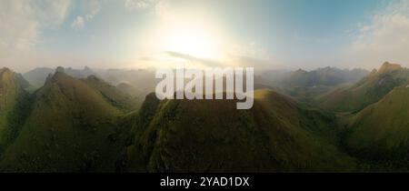 Panorama vue aérienne du lever du soleil sur la colline d'herbe de Ba Guang, chaîne de montagnes avec villageois apportant le cheval à paître sur la montagne à Ha Lang, Cao B. Banque D'Images