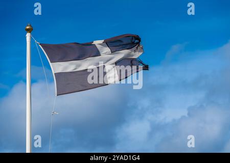 Le drapeau de Cornouailles dans le vent, le drapeau de St Piran, croix blanche sur fond noir Banque D'Images