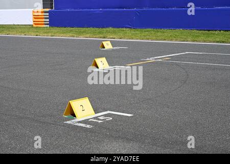 Gros plan des pancartes indiquant la place sur la ligne de départ sur la piste de course Banque D'Images