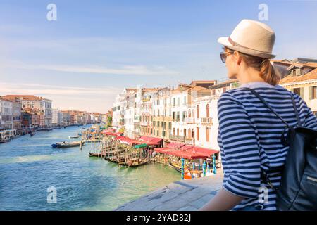 Jeune femme touriste voyageant dans la ville de Venise, Italie, regardant du pont du Rialto à Venise, Italie. Banque D'Images