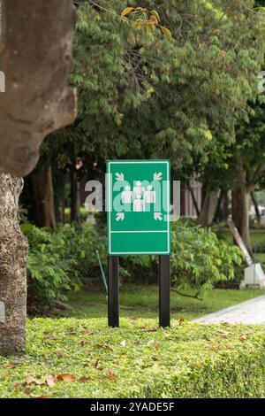 Un panneau de point de rassemblement, bien en vue sur un arbre et un bâtiment en toile de fond, sert de guide crucial pour les individus pour rassembler de l'UA en toute sécurité Banque D'Images