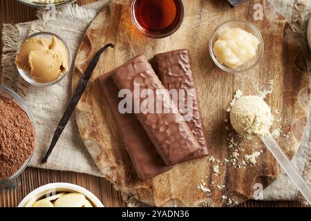 Barres de chocolat protéinées saines avec des ingrédients - poudre de protéines de lactosérum, beurre d'arachide et de cacao, cacao cru, miel, gousse de vanille et sirop d'érable Banque D'Images