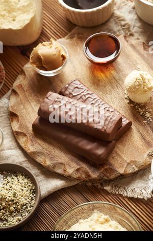 Barres de chocolat protéinées saines avec des ingrédients - poudre de protéines de lactosérum, beurre d'arachide, graines de chanvre, cacao et sirop d'érable Banque D'Images