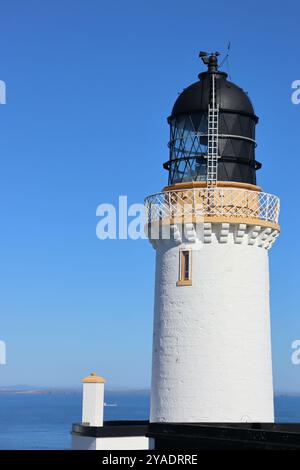 phare blanc jaune et noir sur la côte nord de l'écosse à dunnet head avec fond de ciel bleu Banque D'Images