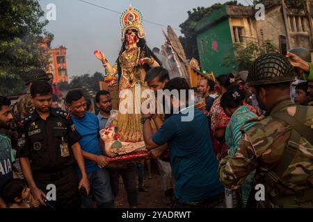 Les dévots hindous portent une idole de la déesse Durga pendant le dernier jour du festival Durga Puja. Le festival Durga Puja est célébré dans tout le Bangladesh et culmine dans l'immersion des idoles de la déesse hindoue Durga pour symboliser le pouvoir et le triomphe du bien sur le mal dans la mythologie hindoue. Banque D'Images