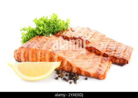 Délicieux filets de saumon grillés aux grains de poivre, citron et laitue isolés sur blanc Banque D'Images