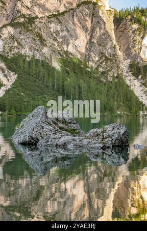 Roches escarpées se reflétant dans les eaux émeraude de Pragser Wildsee, avec des forêts alpines et des falaises de calcaire dans les Dolomites, Tyrol du Sud Banque D'Images